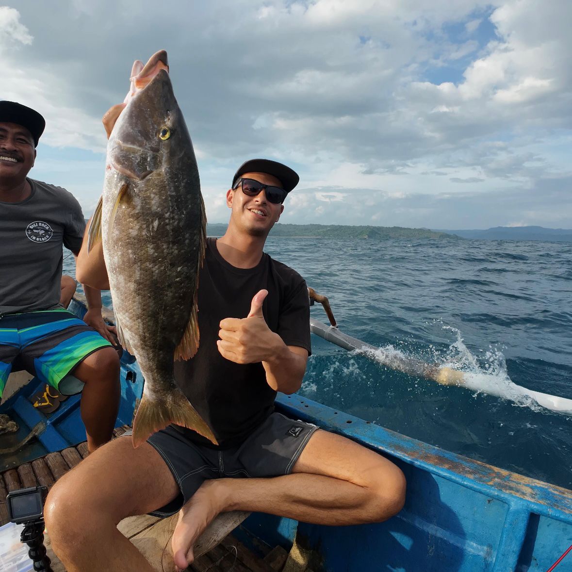 Angler with catch and ocean backdrop