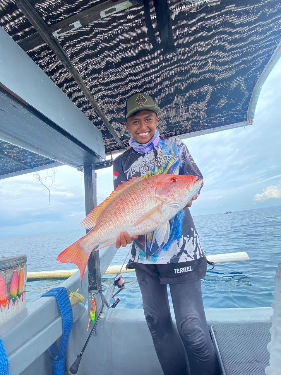 Crew holding a red snapper with lures visible