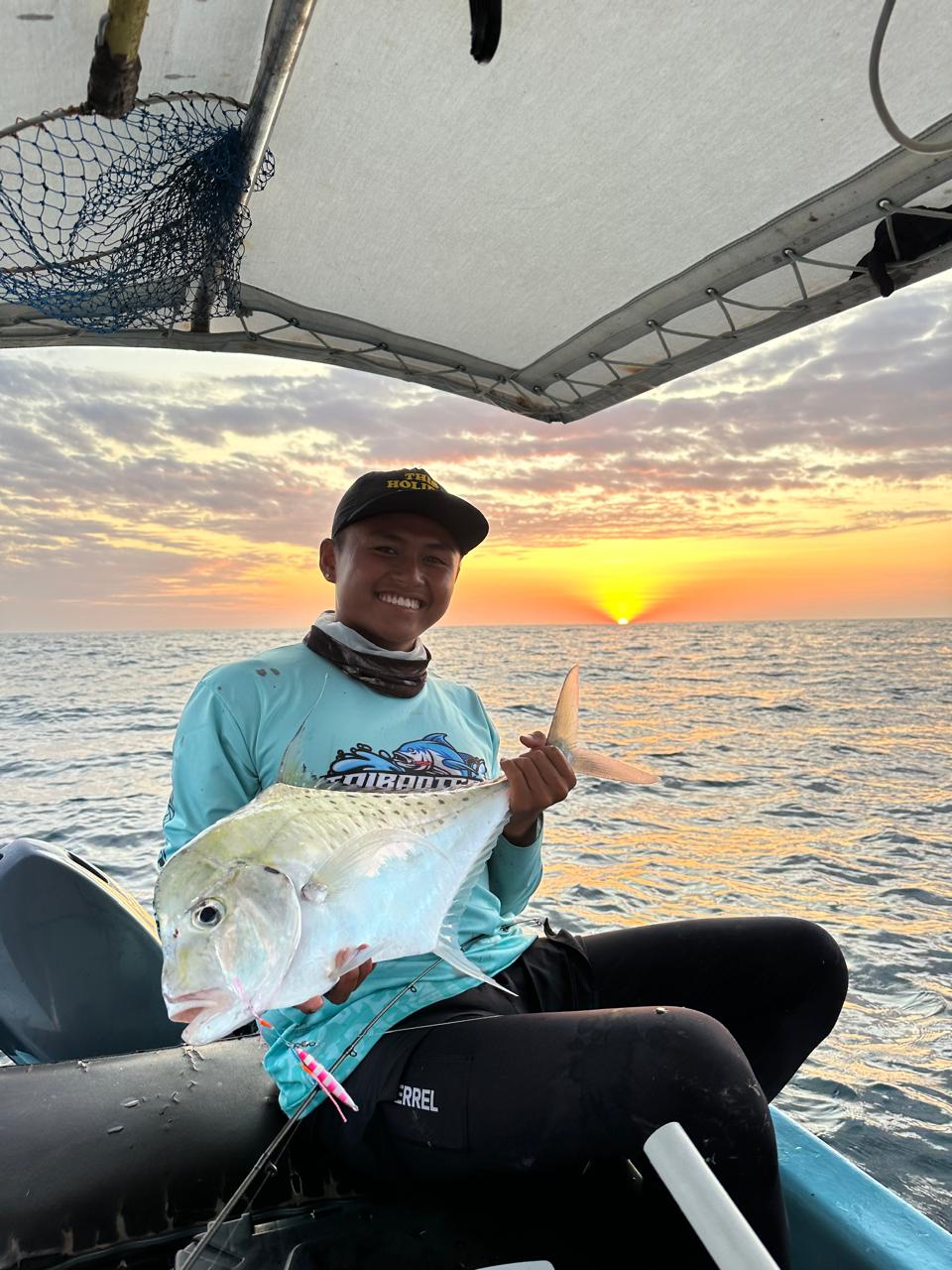 Fisherman showing off catch at sunset