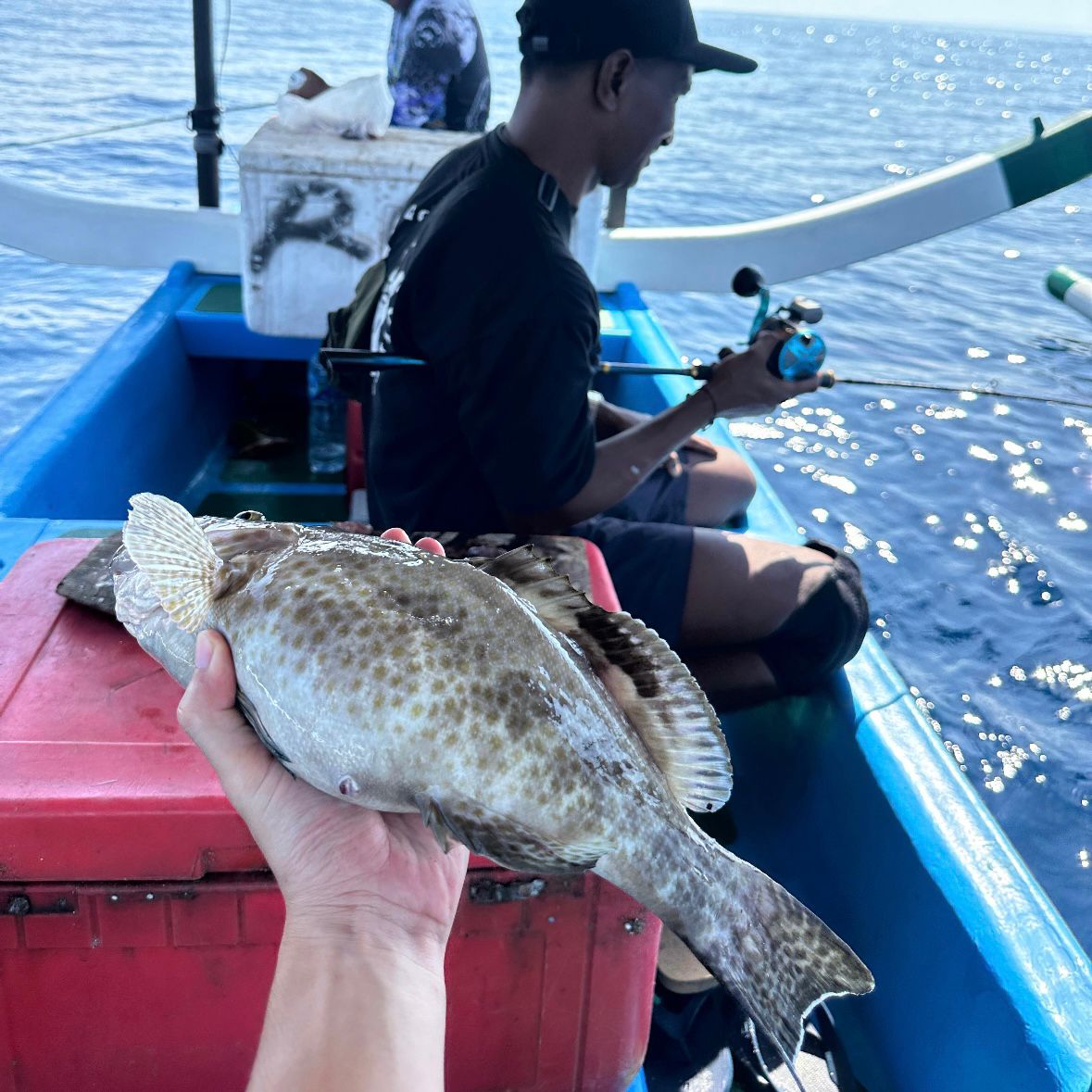 Fisherman with catch and full crate on deck